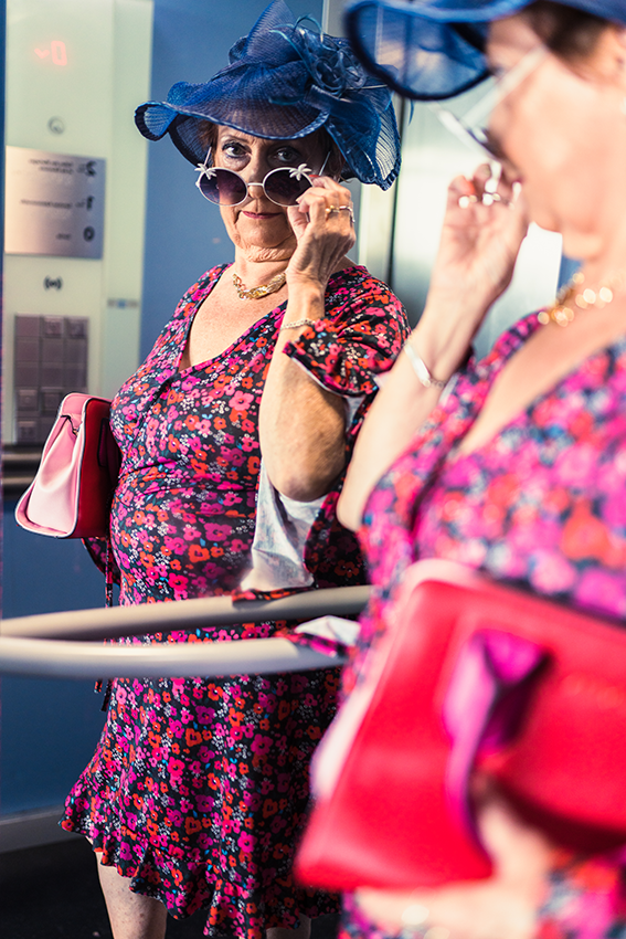 Une personne âgée fait la pose lunettes de soleil légèrement baissée sur le nez devant le miroir de l'ascenseur de la mairie - 7 