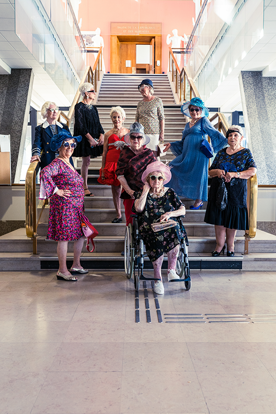 9 personnes âgées très élégamment vêtues posent dans les escaliers menant jusqu'à la salle des mariages - 10 
