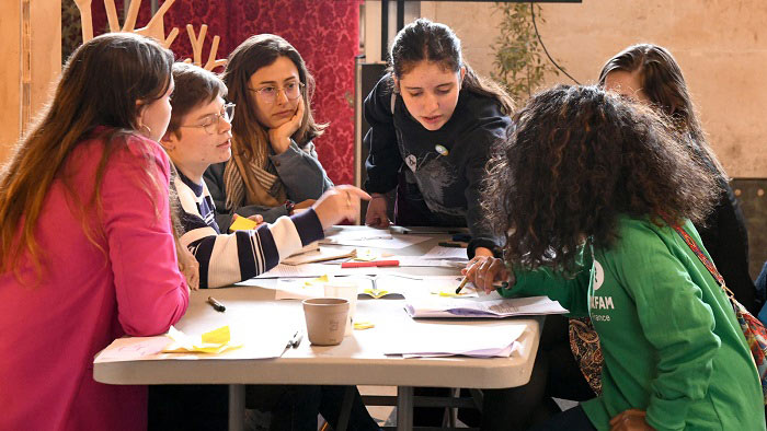 6 jeunes en train d'échanger et de réfléchir autour d'une table