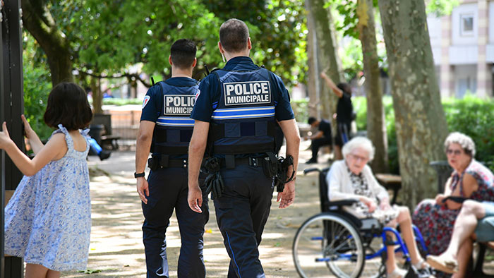 Vue de dos de deux policiers municipaux dans un parc de la ville