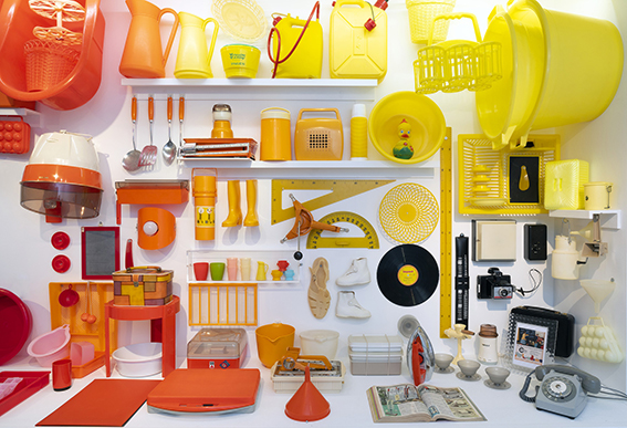 Exposition d'objets en plastique de couleur orange et jaune de la période des Trente Glorieuses 